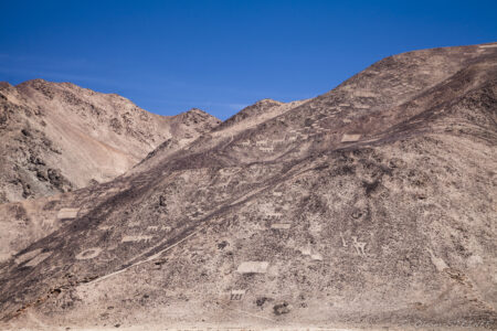 Geoglyphs - Pintados Desert landscape in Fiambala, Argentina, with rugged mountains and clear blue sky.
