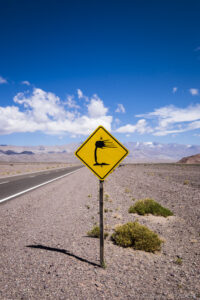 Fiambala desert road sign warning of water hazard in the Argentine desert landscape. Road sign in Fiambala, Argentina, warning of a water hazard.
