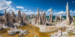 Scenic view of Mono Lake's iconic tufa formations, showcasing natural limestone structures against a vibrant sky. Unique tufa limestone formations at Mono Lake with blue sky and clouds in the background.