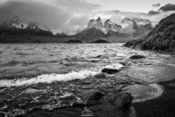 Stunning black and white landscape of a mountain lake with dramatic peaks and calm waters, captured by Olivier Steiner Photography. Black and white photo of a mountain lake with rugged peaks in the background.