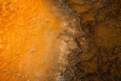 Close-up of mineral formations highlighting rich orange and dark brown colors, emphasizing natural geological textures. Vivid mineral deposits with striking orange and brown hues, showcasing natural textures and patterns.