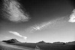 Black and white mountain landscape with expansive sky and clouds, captured by Olivier Steiner Photography. Stunning black and white landscape with mountains and dramatic sky.
