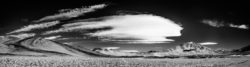 Stunning black and white mountain landscape featuring dramatic clouds, rugged terrain, and expansive views, captured by Olivier Steiner Photography. Black and white mountain landscape with dramatic clouds and rugged terrain.